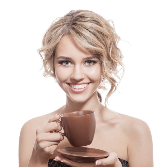Young happy woman with an aromatic coffee in hands. Isolated